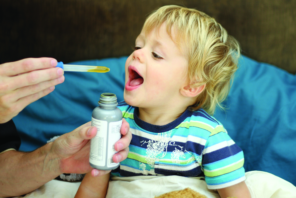 Doctor Administering Oral Medication to Young Boy